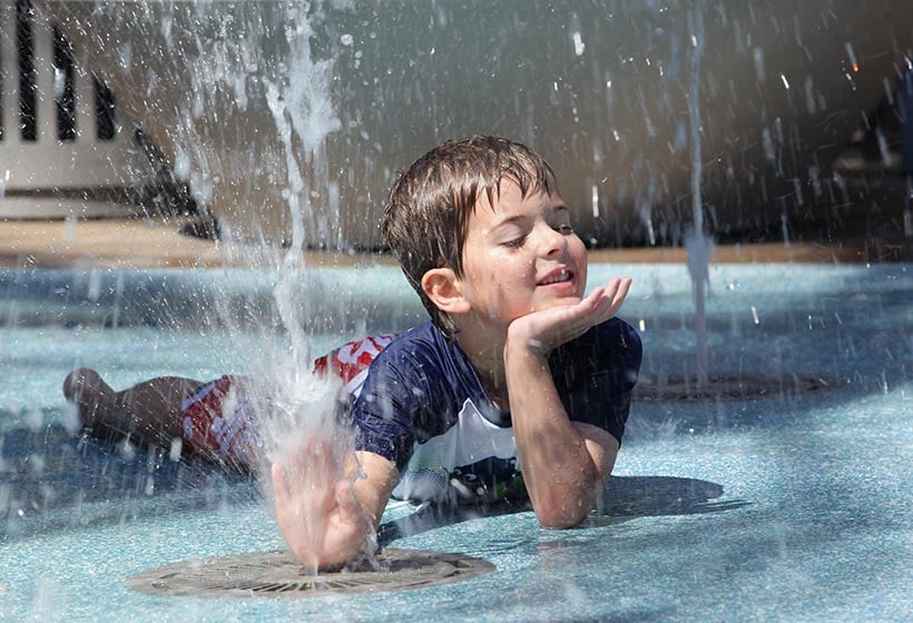 child plays on splash pad surface